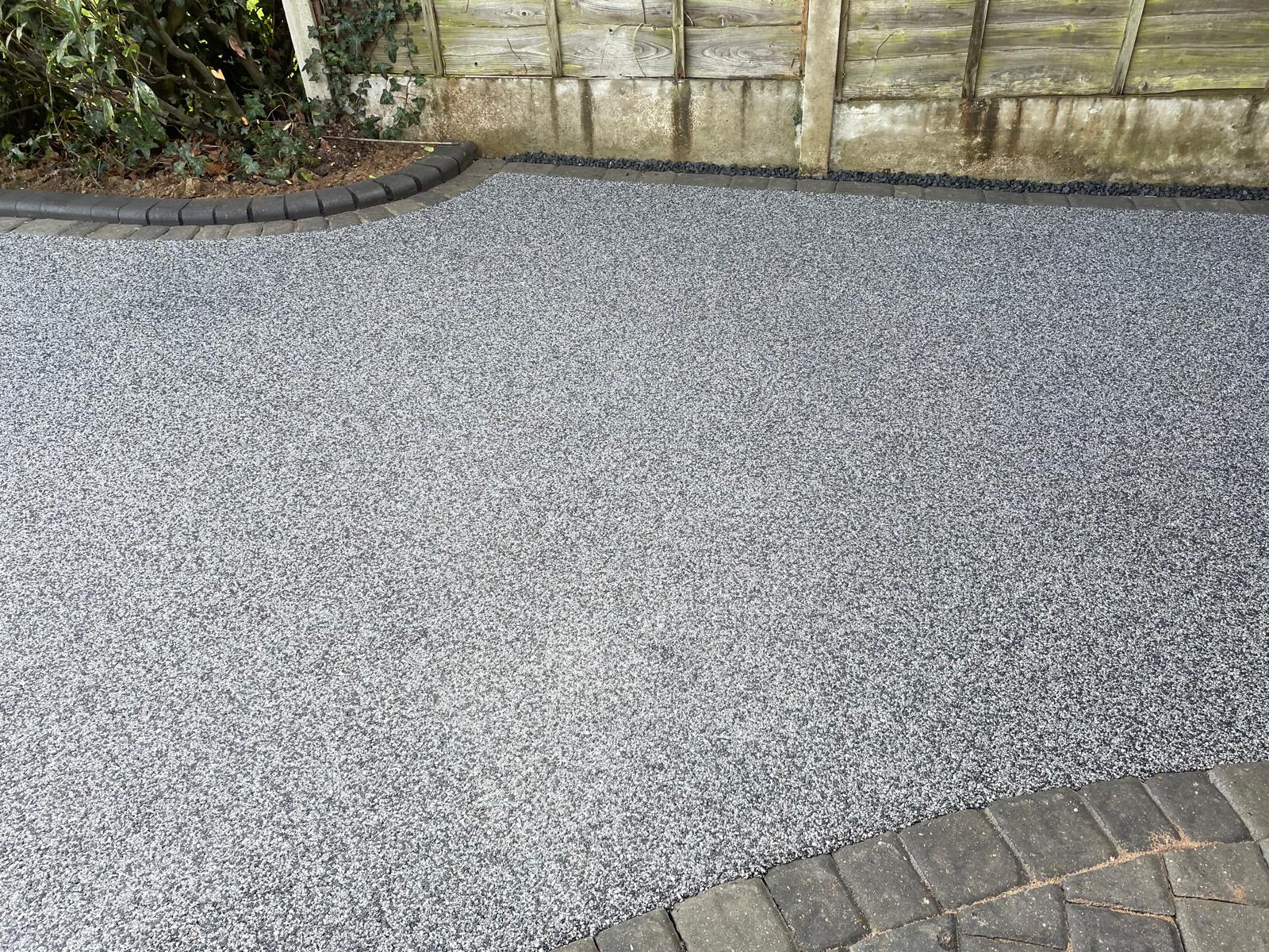 Close detail of silver-grey resin-bound surface with charcoal cobble edging